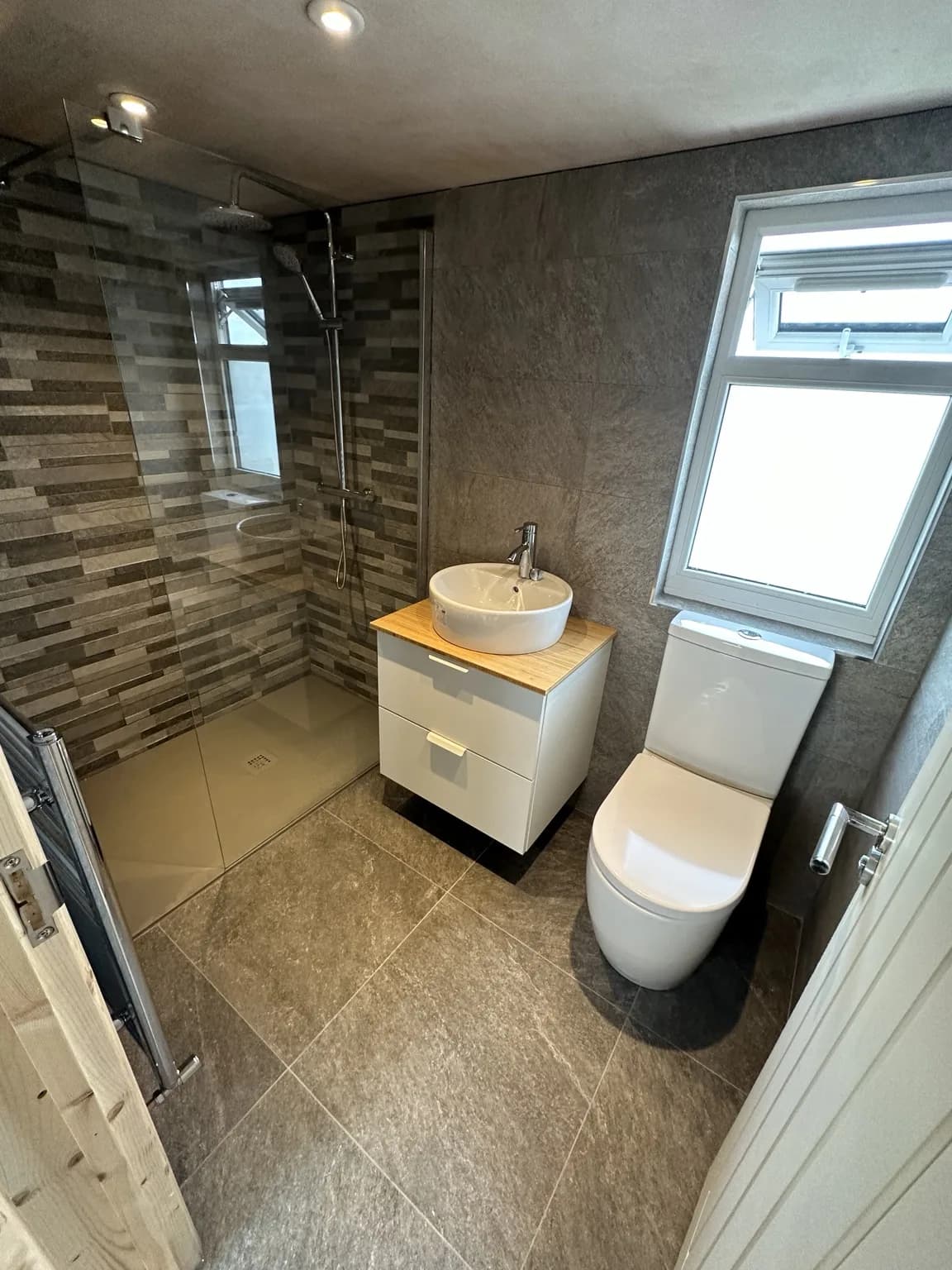 Contemporary residential bathroom with walk-in shower, vanity and WC