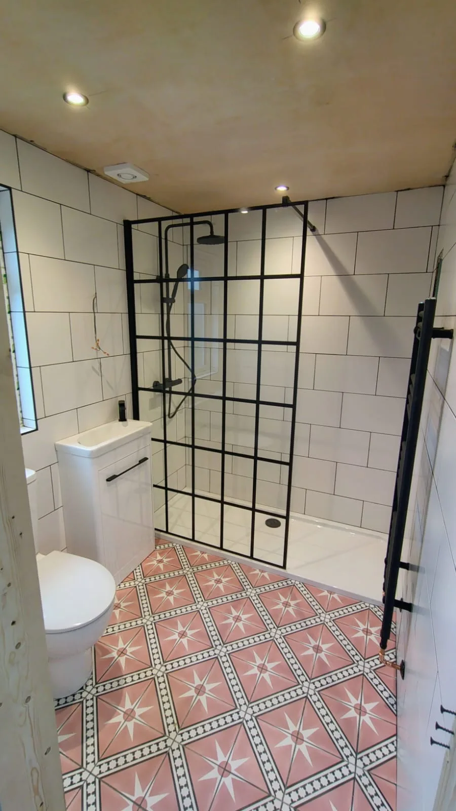 Shower room with patterned floor, metro tiles and black-framed enclosure