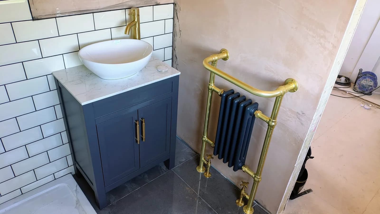 Shower-room installation with brushed-brass fittings, vanity and feature radiator