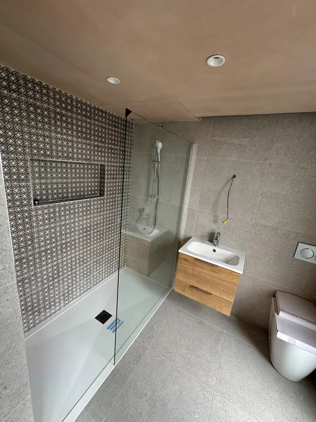 Marble-effect bathroom with walk-in shower, feature tiling and vanity